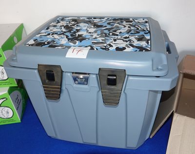 une glacière bleue posée sur un tapis bleu à côté d'une boîte