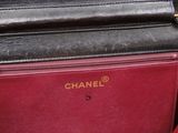 a black and red purse sitting on top of a red chair