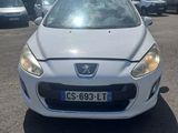 La voiture blanche est garée sur le parking, à côté d'autres voitures.
