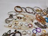 many different types of rings and bracelets on the table