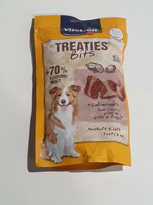 un sac de friandises avec un chien assis à côté