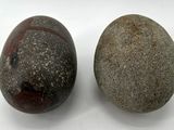 two rocks sitting next to each other on a white surface