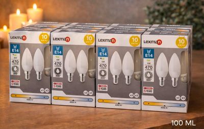 trois ampoules blanches posées sur une table, à côté d'une bougie allumée