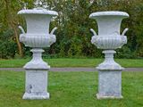 deux vases blancs posés l'un sur l'autre dans l'herbe