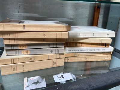 several books are stacked on top of each other on a glass table
