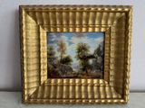 une image d'un tableau représentant un paysage dans un cadre doré
