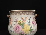 a vase with flowers painted on it sitting on a table