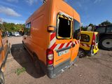 an orange van that has been vandalized in a parking lot