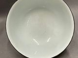 a person holding a white bowl on a table