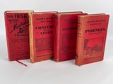 trois livres rouges superposés sur une surface blanche