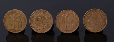 quatre pièces d'or sont alignées sur une surface noire