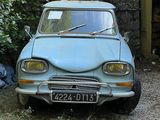 une petite voiture bleue garée devant un immeuble