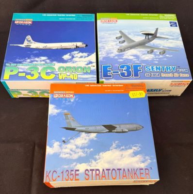 trois boîtes contenant des maquettes d'avions, posées sur une surface noire