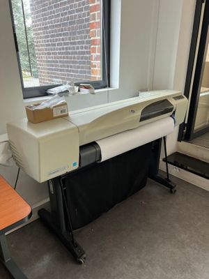 une photo d'une imprimante posée sur un bureau devant une fenêtre