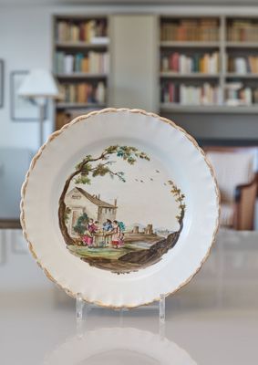 une assiette avec une peinture posée sur une table