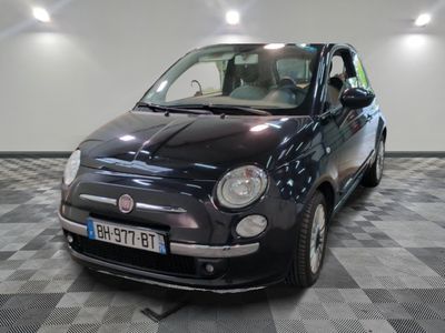 une petite voiture noire garée sur un sol en damier