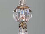 a glass vase that has a gold decoration on it