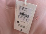 the label on a pink shirt is attached to a hanger
