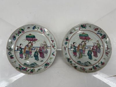 pair of chinese porcelain plates with figures on them on a white surface