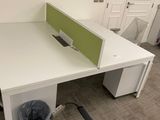 a white desk with a green privacy panel on top of it