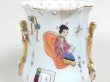un vase orné d'une femme, posé sur une table