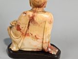 figurine of a woman sitting on a bench with a cat