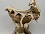 une figurine représentant une femme assise sur un vase