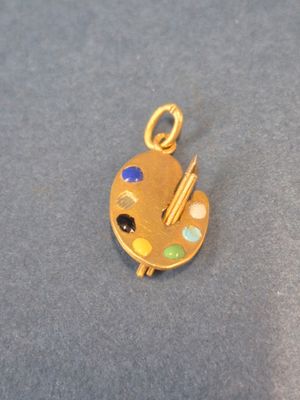 une image représentant un pendentif plaqué or orné d'une palette et d'un pinceau