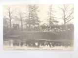 a black and white photo of a group of people standing in front of a pond