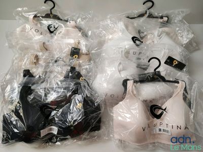 deux paires de soutiens-gorge emballées dans des sacs en plastique, posées sur une table