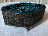 un vieux saladier en verre bleu posé sur une table blanche
