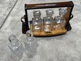 four glass bottles in a wooden case on the floor