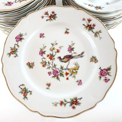 a stack of plates with birds and flowers on them