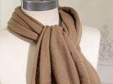 the brown scarf is hanging on a mannequin on a mannequin stand