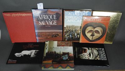 Plusieurs livres sont posés sur une table, avec une horloge en arrière-plan.