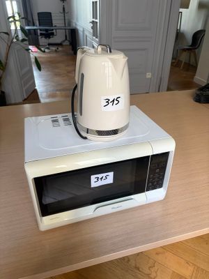 a microwave sitting on top of a table with a toaster on top of it