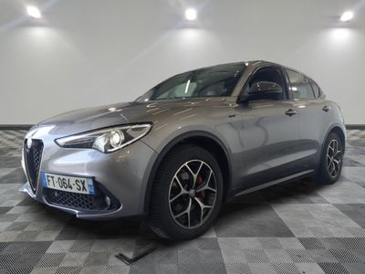 un SUV Alfa gris garé dans un garage au sol carrelé
