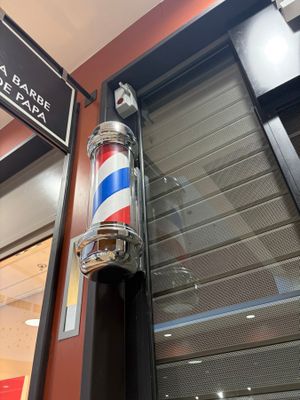 a barber pole in front of a building with a sign on it