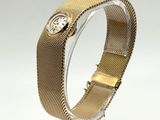 Gros plan sur une montre-bracelet posée sur un support, sur une surface blanche