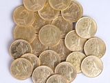 a pile of gold coins sitting on a white surface