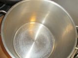 a metal bowl sitting on top of a stove next to a stove top