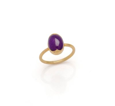 a close up of a gold ring with a purple stone