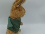 a small stuffed rabbit with a green scarf on it ' s neck