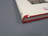 un livre blanc à la couverture rouge posé sur une table