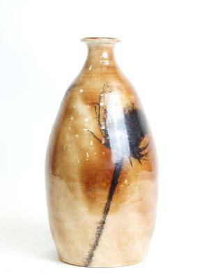 a brown vase with a black and white design on it