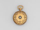 an antique gold pocket watch with a diamond in the center