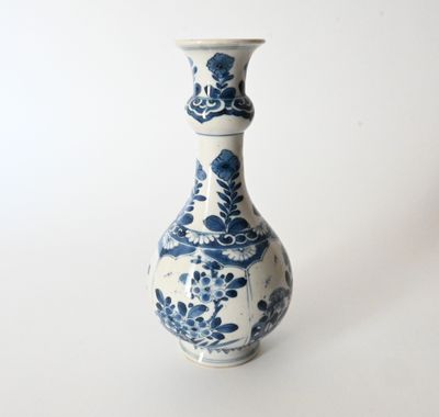 a blue and white vase sitting on a white surface