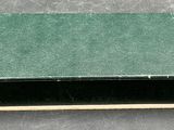 a green box with a black lid sitting on a table
