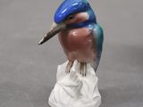 a figurine of a blue bird on a white base