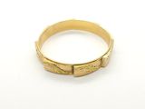 a close up of a gold ring on a white surface